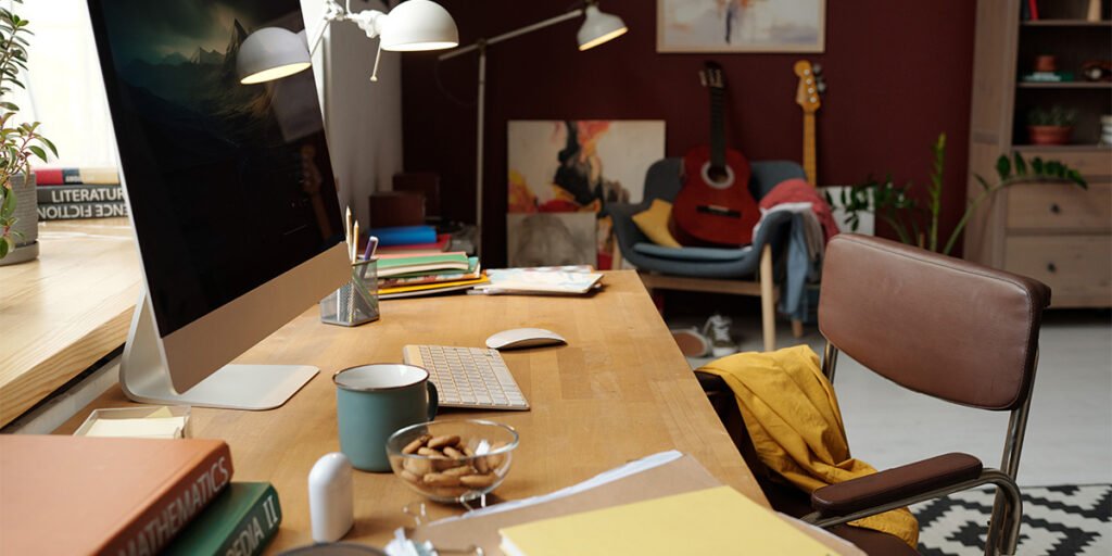 Cozy home office desk with a computer, notebooks, and coffee — a freelancer's workspace